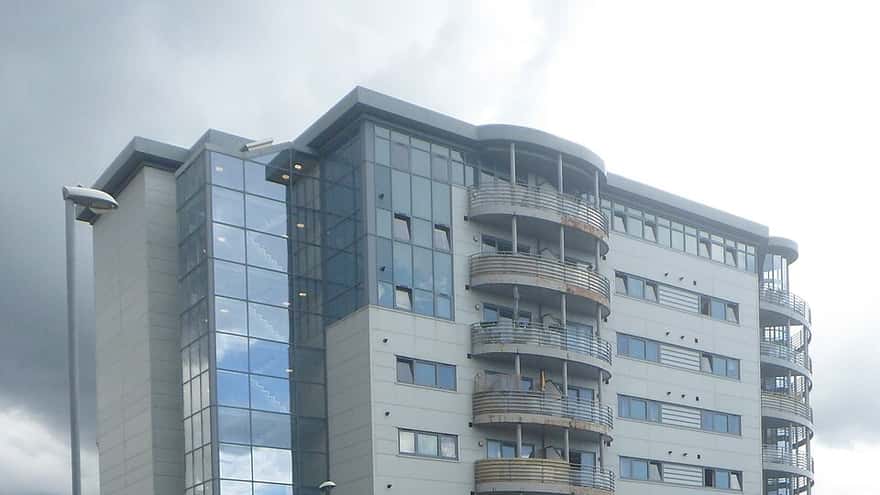 Modern multifamily apartment building with balconies, the kind of asset physicians access through syndication